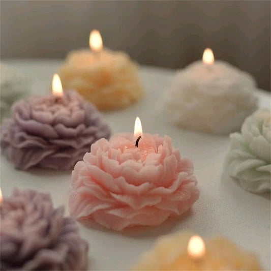 Decorative candles shaped like flowers on a soft surface with a blurred background